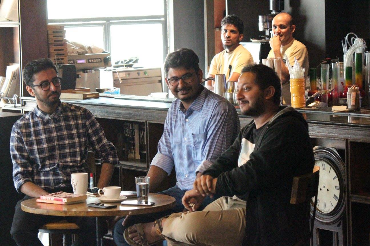 Small group of Sip and Swap attendees seated at a cafe table with books and coffee